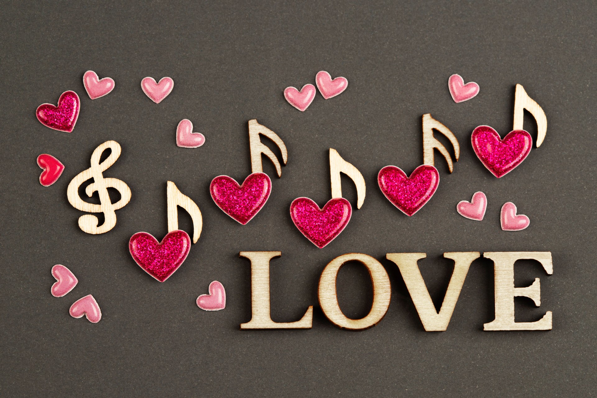 Musical wooden notes with hearts and word LOVE